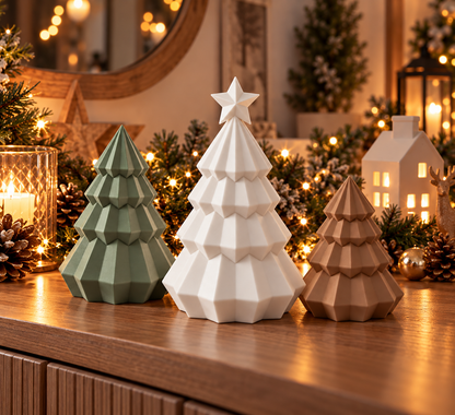 Drei geometrische Weihnachtsbäume in Olivegrün, Weiß und Braun auf einem weihnachtlich dekorierten Tisch.